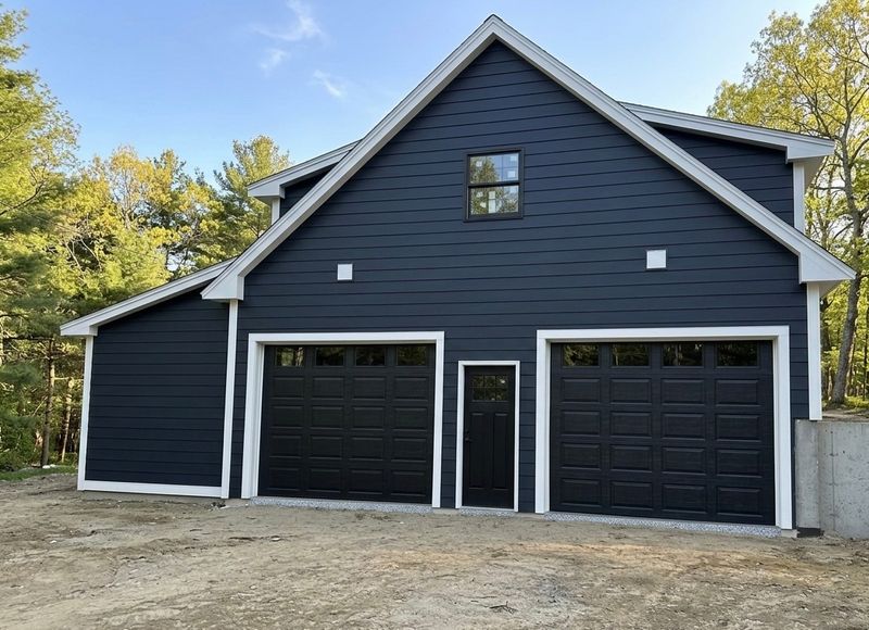 Navy blue new construction garage with black dual doors and white trim in Massachusetts