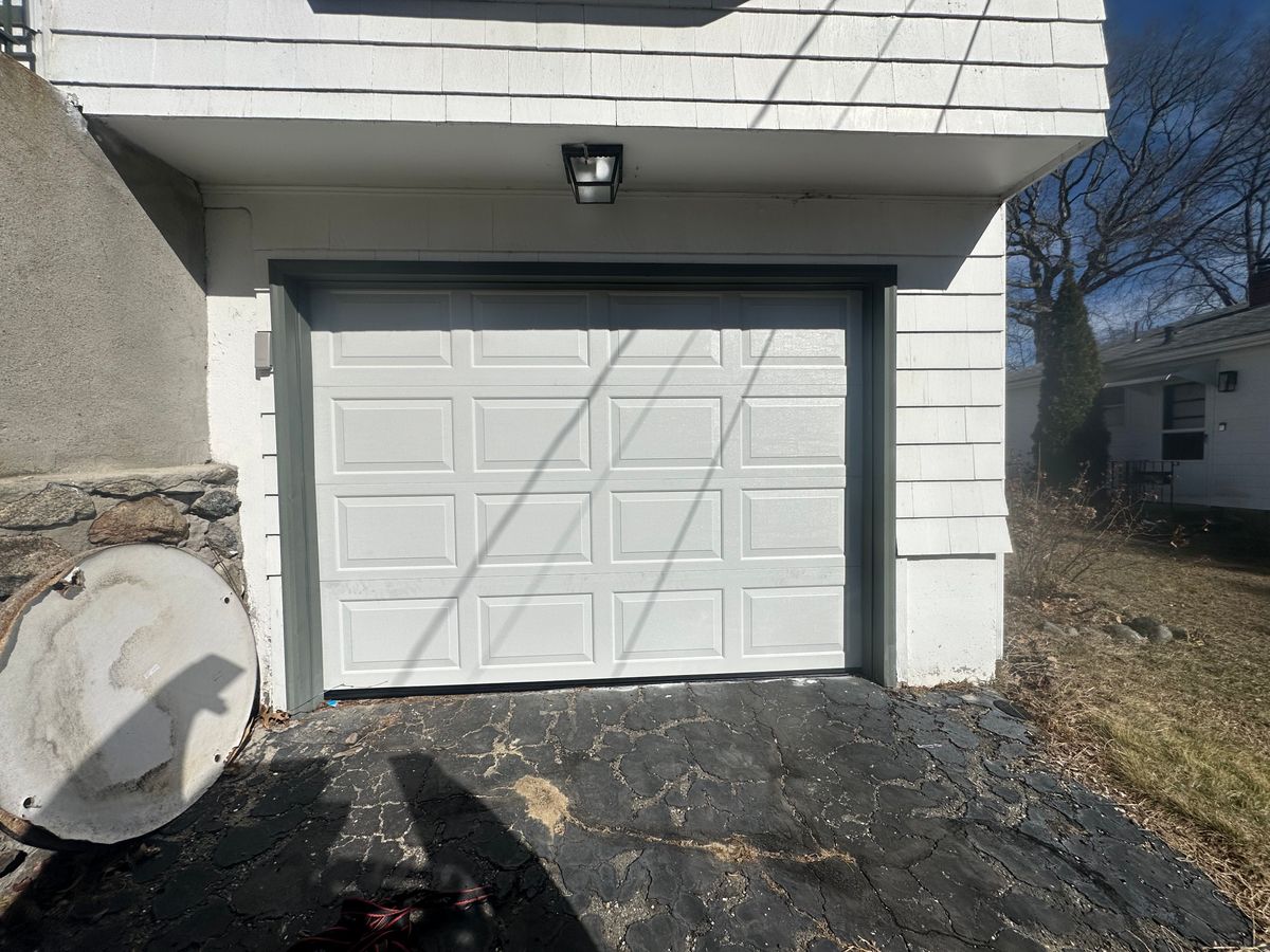 White panel garage door with green trim installed on Massachusetts home